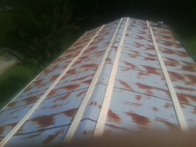 Rusted metal roof panels with new wood purlins before replacement — Storm Damage Roof Repair in Gentry by Roofing Brothers
